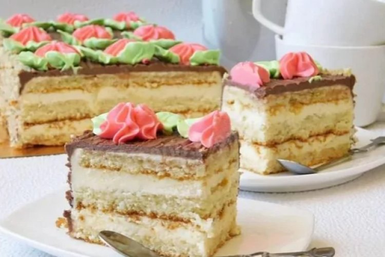 Классический торт из мягкого бисквита, пропитанного коньяком и промазанного кремом из нежнейших сливок с украшением в виде розочек с зелеными листьями из масляного крема.